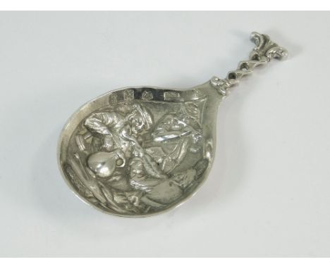 DUTCH CADDY SPOON. A Dutch silver caddy spoon cast a tavern scene. Stamped B.H.M. Length 6.9cm. English import marks for 1913