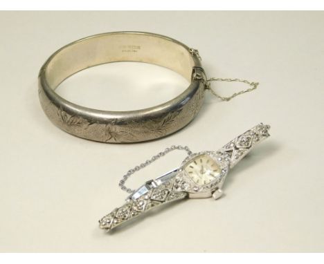 SILVER BANGLE ETC. An engraved hinged silver bangle & a lady's Rotary wristwatch, set with marcasite.  Note that all items in