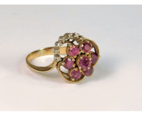 COCKTAIL RING. A ruby flower head & diamond cocktail ring in unmarked yellow metal setting. Size M/N.  Note that all items in