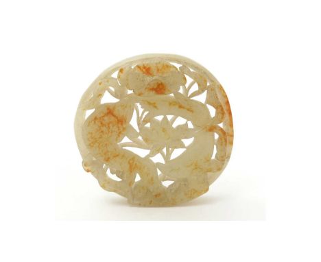 A Chinese carved jade roundel, pierced and carved with carp and water lilies, the pale green stone with rust inclusions, 6cms