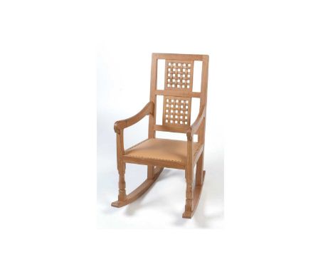 Workshop of Robert 'Mouseman' Thompson (Kilburn): an oak rocking chair, with studded leather seat, carved lattice back, carve