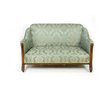 A 19th Century carved mahogany two-seater sofa, the downswept padded arms on carved leaf, berry and scroll supports, the stuf