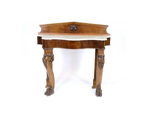 A Victorian mahogany console table, the associated architectural back centred by a carved shield, serpentine marble top above