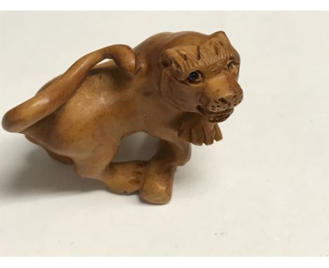 Unusual wooden Japanese Netsuke in the form of a lion, signed to the base