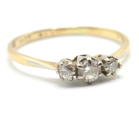 A stamped 18ct gold three stone ring being set with a central round cut diamond flanked by two further round cut diamonds. Ba