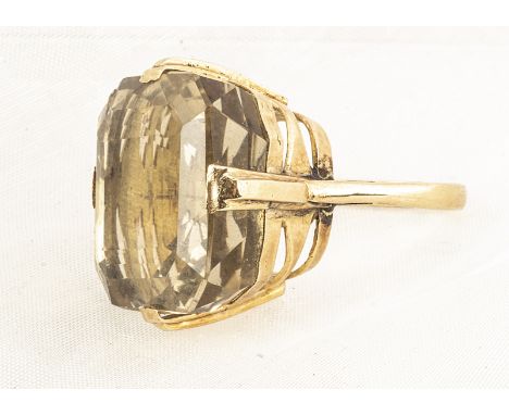 A large yellow metal and citrine cocktail ring, the cushion cut gemstone in four claw setting on a raised basket setting, rin