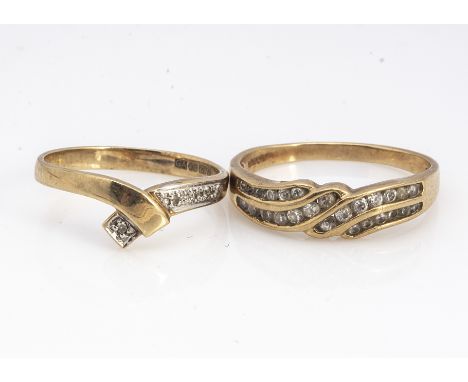 Two diamond rings, including a channel set scroll example, ring size O 1/2 and  another ring size , 4 g 