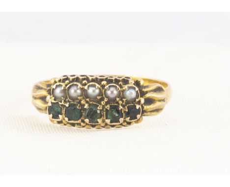 A 19th Century 15ct emerald and seed pearl ring, the two pairs of parallel set gems in scroll gallery on plain shoulders and 