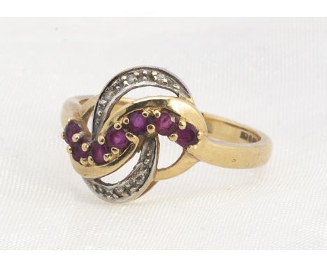 A 9ct gold ruby and diamond two colour crossover dress ring, the knot shaped top claw set with rubies and millegrain set with