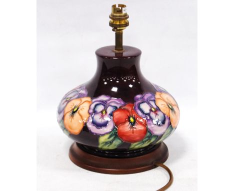 Moorcroft table lamp decorated with all-over floral decoration on an aubergine ground, 20cm high. 