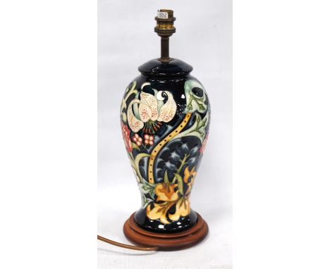 Moorcroft table lamp decorated all-over with floral panels on a blue ground, 27cm high.