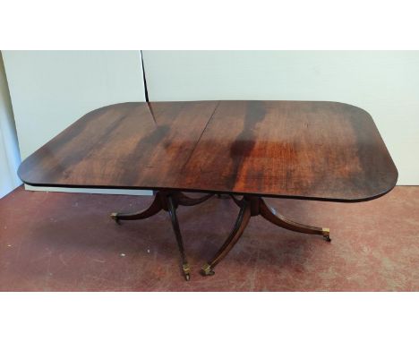 Regency-style mahogany twin-pedestal dining table with additional leaf, on tripod supports with brass caps and castors, 73cm 