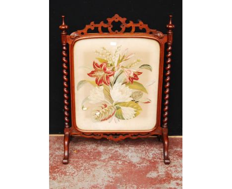 Victorian mahogany firescreen with a Gothic-style trellis top above a glazed needlepoint floral panel, on barley-twist column