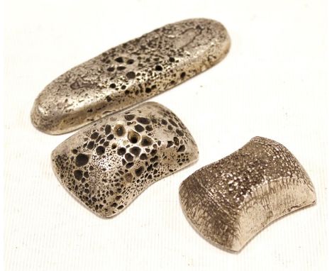 Three Chinese white metal scroll weights, one of oval lozenge form, 10cm long, the two others of waisted rectangular form, 5.