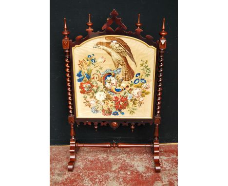 Victorian rosewood firescreen with turned finials above a needlepoint panel depicting an eagle perched on a floral wreath, on