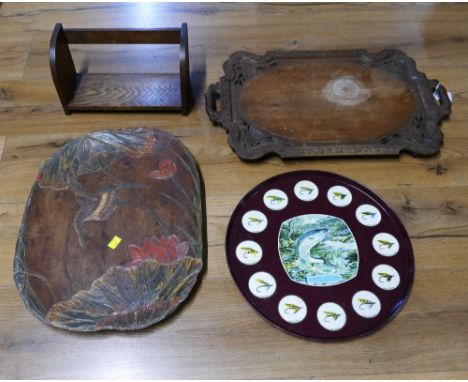 Two wooden hand carved trays, wooden book trough and metal tray decorated with fish