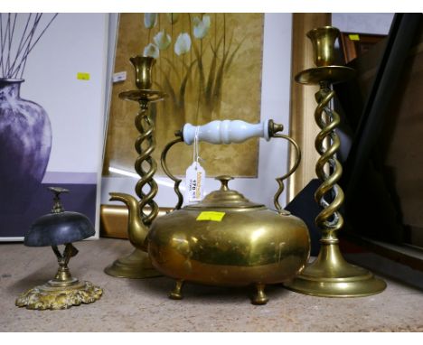 Four items of brassware including a bell, candlesticks and a kettle 