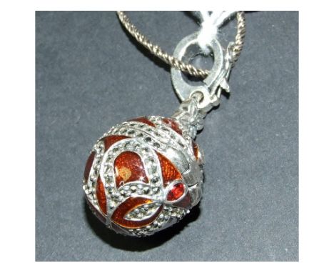 A silver, enamel, marcasite and garnet set egg locket