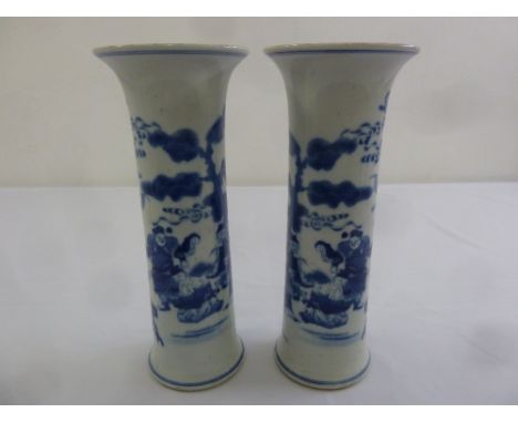 A pair of Chinese Kangxi blue and white cylindrical vases decorated with courtiers in stylised landscapes, marks to bases