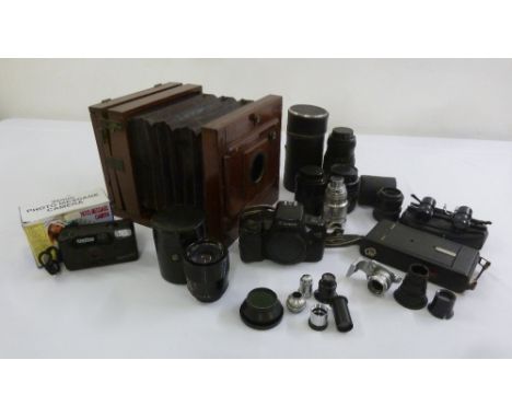 A quantity of camera accessories to include lenses, a bellows camera and light meters