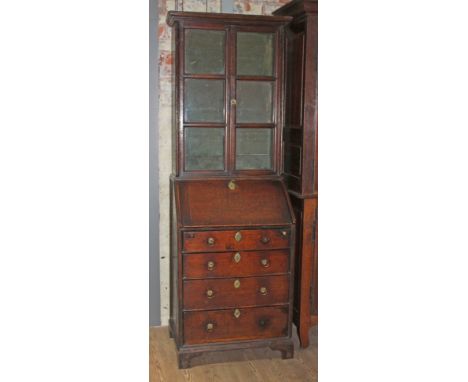 A provincial early 18th century and later oak bureau bookcase of small proportions, the top with six glazed panels, base with