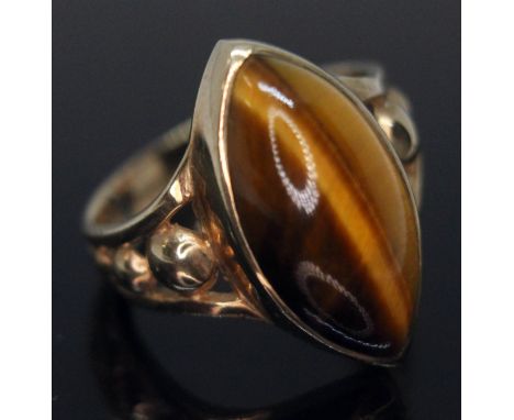 A hallmarked 9ct gold ring set with a marquis cabochon cut tiger's eye, gross wt. 4.39g, size M.  