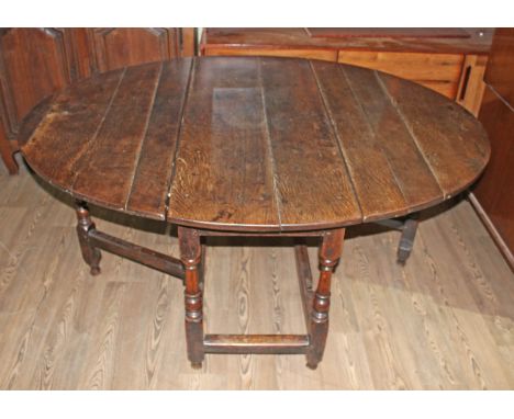 An 18th century joined oak gate leg table, together with eight ladder back and rush seated chairs.&nbsp;Condition - later pie