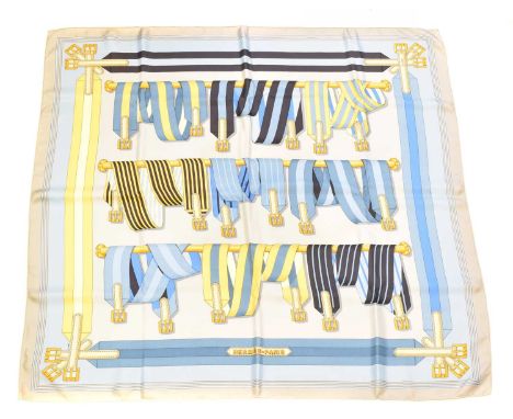 A Hermès "Les Sangles" silk scarf by J. Metz, circa 1985, the cream, grey, yellow and blue ground depicting a belt and buckle
