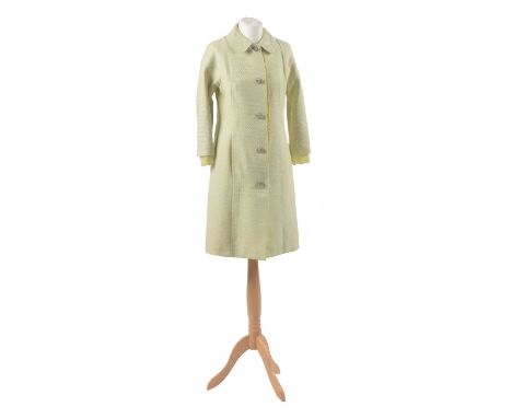 A coat by Dolce &amp; Gabbana, the mid length cream and pale lime green woven coat with lace trim and green enamel and paste 