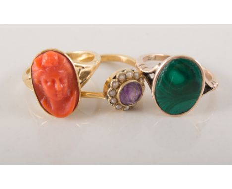 Three dress rings, a yellow metal ring collet set with an oval coral cameo, ring size M, an oval slice of malachite collet se