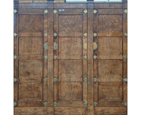 19th century walnut wardrobe, moulded extensions above a frieze,  leading to a trio of panel doors with engraved brass hinges