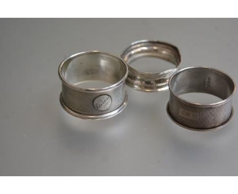 Three various Birmimgham silver napkin rings with engine turned and chased decoration (3)