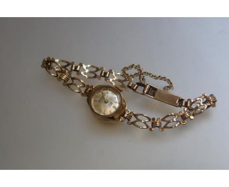A lady's 9ct gold wristwatch with enamel dial, on 9ct link chain bracelet, complete with safety catch (13g)