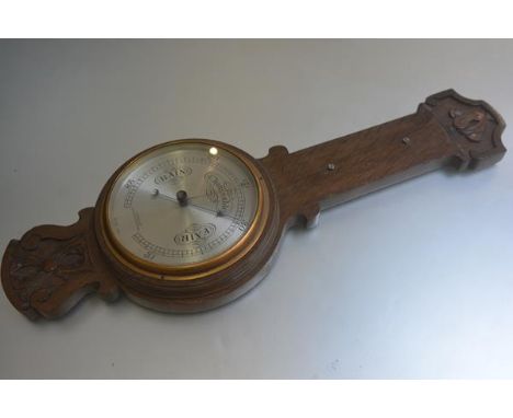 An Edwardian oak carved banjo style wall barometer, retailed by F. Robson &amp; Co., Newcastle upon Tyne, missing thermometer