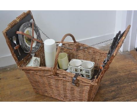 A wicker picnic hamper by Brexton, c.1960 complete with teak handled knives, plates, cups, mugs and flask, with centre handle