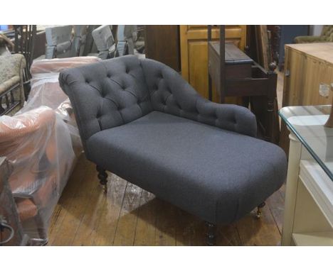 A neat modern chaise longue with upholstered button back and scroll arm, in grey felted wool, raised on turned baluster walnu
