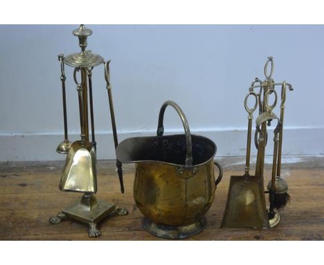 A four piece brass companion set on circular urn finial stand and paw feet, complete with brush etc. and a miniature brass co