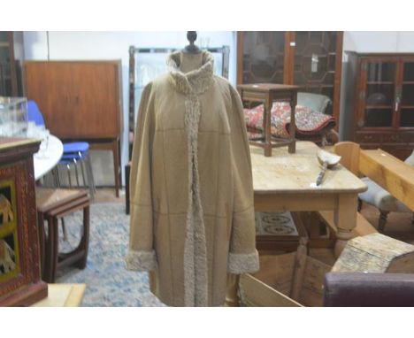 An astrakan blonde tan hide three quarter length reversible coat with slit pockets and button closures (shoulders: 45cm lengt