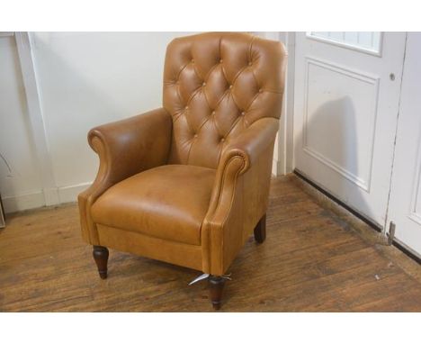 A modern Victorian style tan hide button back club style chair with scroll arms, raised on turned tapered walnut supports (h.