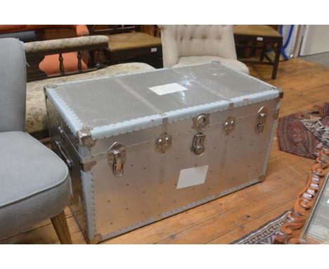 An aluminium bound cabin trunk with blue fablon lined check interior, with strap handles to side (h.54cm x 103cm x 53cm)