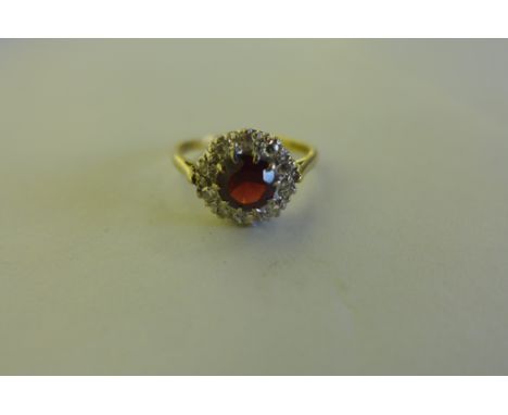 A pretty 18ct gold diamond cluster ring, with central red stone, surrounded by ten diamonds, size P, approx weight 3.7 grams,