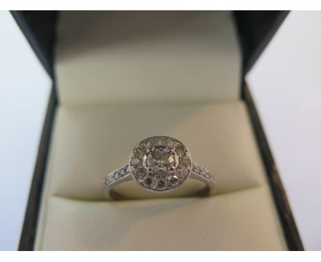 A pretty platinum diamond cluster ring in a modern setting, the central diamond measuring approx 0.25ct, surrounded by twelve