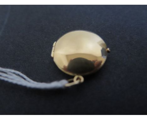 A circular 18ct yellow gold locket, diameter 21mm, approx weight 3 grams, light surface marks consistent with use 