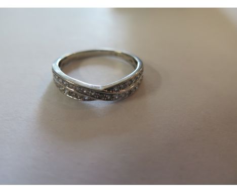 A platinum and diamond half eternity crossover ring, set with 35 round cut diamonds totaling 0.36ct, fully hallmarked, size O