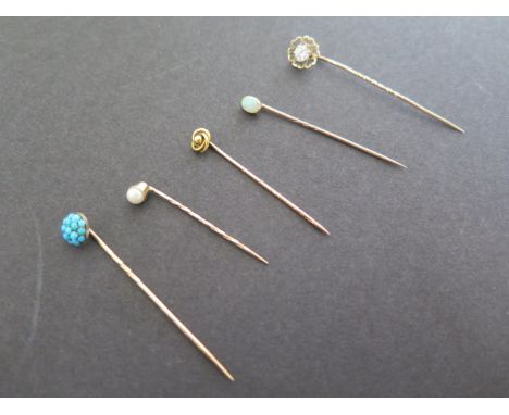 Five gold stick pins, unmarked but tested to 9ct and above, set with various stones including opal, turquoise and pearl, weig