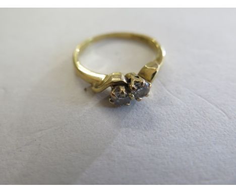 An 18ct and diamond cross over style ring, set with two diamonds each approx 0.125cts, total 0.25 ct, size M, good condition,