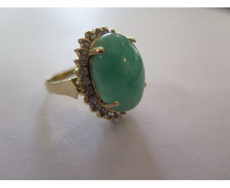 A stunning jade and diamond 18ct gold ladies ring, the central jade stone measuring 17.4 x 13.2mm, polished to cabachon form 