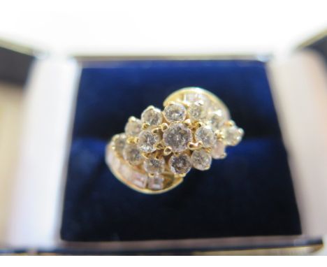 An 18ct fine diamond cluster ring set with fifteen brilliant cut diamonds and ten baguette cut diamonds, size M, approx 2.4ct