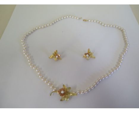 A pearl necklace, with floral pendants and matching earrings, clasp marked 14ct, weight of earrings approx 4 grams, necklace 