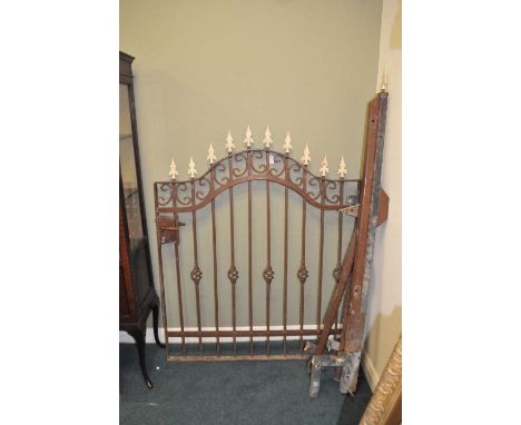 A painted cast iron garden gate, of arched form, with scrolling frame and pointed finials, 138 x 112cm, together with associa